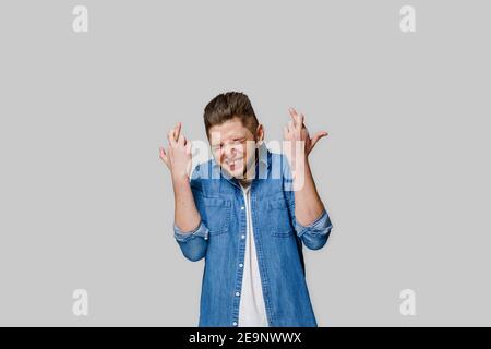 Heureux homme beau croise les doigts et gagne le pari en ligne et de faire des émotions folles. L'homme caucasien regarde dans le téléphone . Arrière-plan blanc isolé. Onlin Banque D'Images