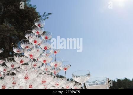 Pyramide de verres avec champagne et cerise rouge à l'intérieur lors d'une réunion d'affaires le jour de l'été. Cocktails alcoolisés pour les clients. Réunion d'affaires en plein air avec Banque D'Images