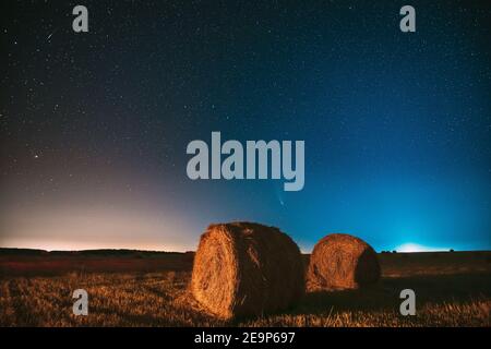 Comet Neolise C2020 F3 dans Starry Sky de nuit au-dessus de Haystacks dans le champ agricole d'été. Étoiles de nuit au-dessus du paysage rural avec balles de foin après Banque D'Images