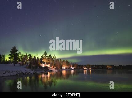 aurores boréaux au-dessus d'un lac gelé et enneigé Banque D'Images