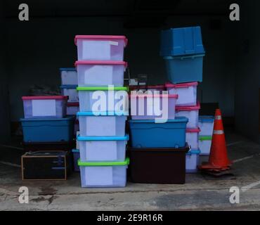 Pile de récipients en plastique translucide sur sol en ciment dans la salle de stockage, mise au point sélective Banque D'Images