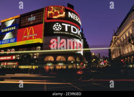 Londres, Angleterre, Royaume-Uni. Des lumières striées sont à l'avant des écrans publicitaires de lumière électrique représentant de Piccadilly Circus de Londres. Banque D'Images