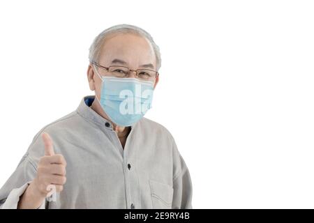 Asiatique senior homme aîné avec masque de visage main montrant des pouces up isolé sur fond blanc avec masque Banque D'Images