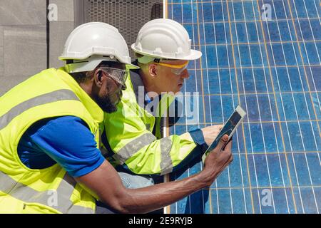 Techniciens de maintenance du panneau solaire et de vérification de la cellule travaillant avec la tablette pour le concept d'énergie verte renouvelable alternative à la maison Banque D'Images