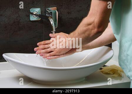 Photo en gros plan du lavage des mains des médecins sous l'eau courante pour la protection de la pandémie de coronavirus covid 19 Banque D'Images