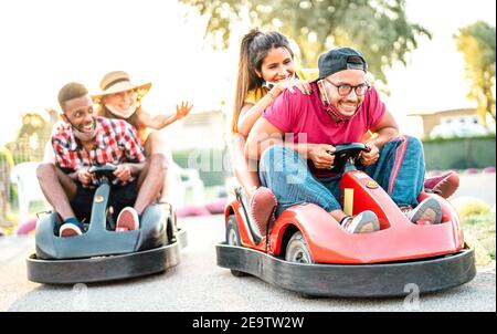 Des amis de Milenial s'amusent sur le terrain de jeu des enfants lors du kart Race - jeunes avec masque de visage en compétition sur mini Course automobile - Nouveau style de vie normal Banque D'Images