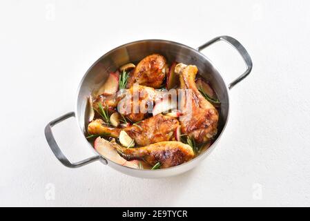 Pilons de poulet cuits avec des pommes et des herbes sur fond blanc Banque D'Images