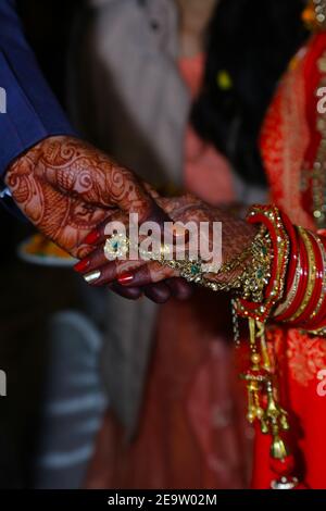 Marié tenant main mariée avec bracelets et mehndi en indien photographie de mariage avec mise au point sélective Banque D'Images