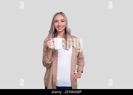 Fille tenant une tasse à café. Fille avec une tasse de café dans les mains. Tasse à thé. Concept du matin Banque D'Images