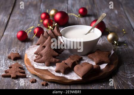 Biscuits épicés au chocolat de Noël faits maison avec glaçage au sucre pour la décoration sur une table en bois, horizontale Banque D'Images
