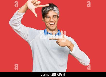 Jeune hispanique portant des vêtements décontractés souriant faisant cadre avec les mains et les doigts avec le visage heureux. Créativité et concept de photographie. Banque D'Images