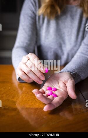 La femme prend des pilules de médicaments. Analgésique à main ouverte femelle. Concept des personnes souffrant de dépression et de problèmes de santé Banque D'Images