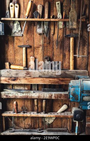 Outil de travail rétro à l'atelier de menuiserie. Variante de pinces, marteau, tournevis, burin, foret et autres outils à main sur fond de bois Banque D'Images