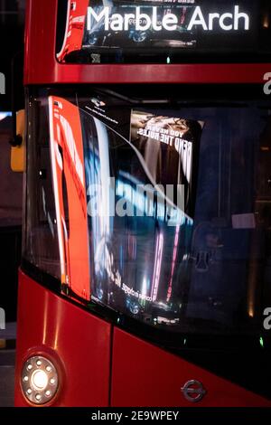 Des images et des clips vidéo des publicités de détail de Piccadilly Circus, dans le West End de la capitale, le 5 février 2021, à Londres, en Angleterre, se reflètent dans le pare-brise d'un bus qui passe. Banque D'Images