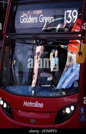 Des images et des clips vidéo des publicités de détail de Piccadilly Circus, dans le West End de la capitale, le 5 février 2021, à Londres, en Angleterre, se reflètent dans le pare-brise d'un bus qui passe. Banque D'Images
