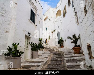 Ancienne ruelle pavée avec maisons blanches traditionnelles à Ostuni, dans la région des Pouilles, dans le sud de l'Italie Banque D'Images