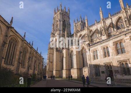 York, Angleterre - 24 2018 février : les visiteurs de la vieille ville historique de York se rassemblent à Deansgate devant la cathédrale de York Minster lors d'une journée d'hiver ensoleillée. Banque D'Images