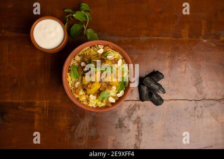 Délicieux poulet épicé biryani, cuisine indienne ou pakistanaise de ramzan. Sur fond fumé. Banque D'Images