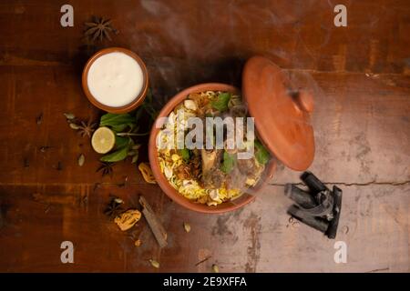 Goght ou Lamb Biryani préparé au riz Basmati servi avec une trempette au yaourt dans un bol en terre cuite. Mise au point sélective Banque D'Images