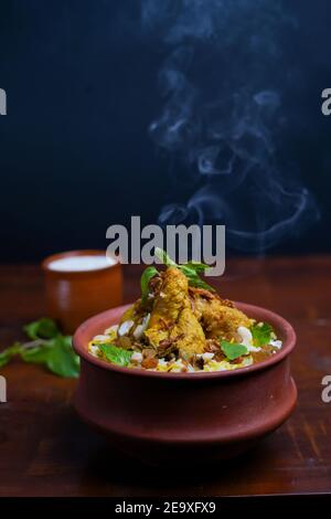 Délicieux poulet épicé biryani, cuisine indienne ou pakistanaise de ramzan. Sur fond fumé. Banque D'Images