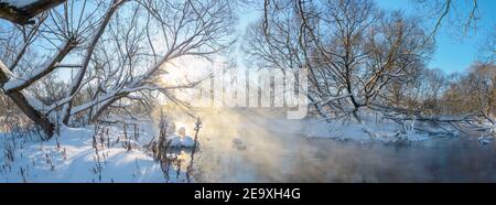 Paysage panoramique hivernal gelé avec rivière forestière pendant le matin ensoleillé de janvier. Banque D'Images