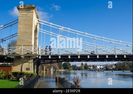 Marlow, Buckinghamshire, Royaume-Uni. 6 février 2021. Les gens se tiennent sur le pont suspendu de Marlow en regardant les inondations. Un avertissement d'inondation est en place pour la Tamise à Marlow, après une période de précipitations récentes. Il est conseillé aux résidents vivant près de la Tamise d'activer leurs produits de protection contre les inondations. Des inondations sont attendues. Les niveaux de la rivière restent élevés et le sentier de la Tamise est inondé. L'Agence de l'environnement s'attend à ce que les niveaux des rivières augmentent de nouveau ce week-end. Crédit : Maureen McLean/Alay Live News Banque D'Images