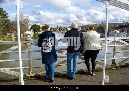 Marlow, Buckinghamshire, Royaume-Uni. 6 février 2021. Les gens s'arrêtent sur le pont Marlow pour observer les niveaux de la rivière. Un avertissement d'inondation est en place pour la Tamise à Marlow, après une période de précipitations récentes. Il est conseillé aux résidents vivant près de la Tamise d'activer leurs produits de protection contre les inondations. Des inondations sont attendues. Les niveaux de la rivière restent élevés et le sentier de la Tamise est inondé. L'Agence de l'environnement s'attend à ce que les niveaux des rivières augmentent de nouveau ce week-end. Crédit : Maureen McLean/Alay Live News Banque D'Images