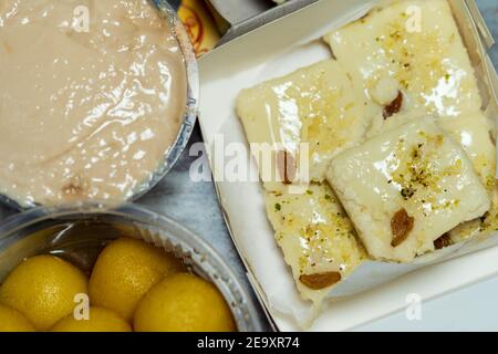 Assortiment de sucreries ou desserts indiens. Image de la poque bengin bengali Komola rasgulla, lait Sandesh et arrangement de buffet de mémisti doi. Banque D'Images