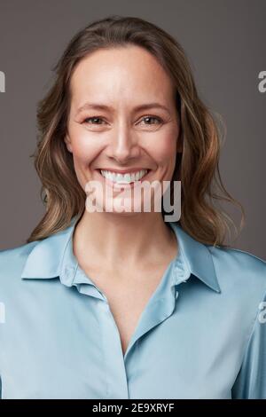 Portrait d'une femme d'affaires mûre et élégante, debout, en studio, regardant l'appareil photo Banque D'Images