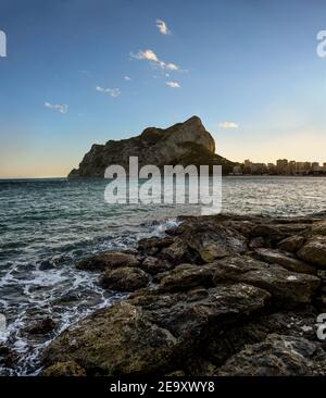 Magnifique coucher de soleil sur la plage de Calpe avec vue sur les vagues, les rochers, la mer et la falaise d'Ifach à Costa Blanca, Espagne Banque D'Images