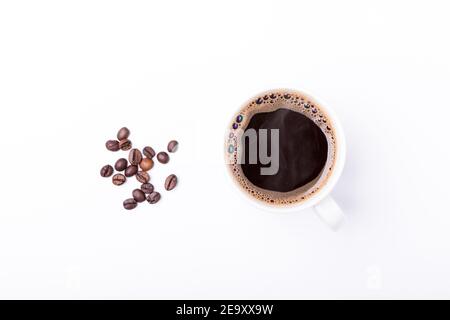 tasse de café blanc isolée sur fond blanc avec peu de café grains de café à côté Banque D'Images