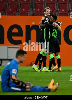 06 février 2021, Bavière, Augsbourg: Football: Bundesliga, FC Augsbourg - VfL Wolfsburg, Matchday 20 à WWK Arena. Le gardien de but Rafal Gikiewicz du FC Augsbourg est assis sur le terrain après le 2:0 tandis que Wout Weghorst (l) et le buteur de but Ridle Bakou (r) du VfL Wolfsburg applaudissent en arrière-plan. Photo: Peter Kneffel/dpa - NOTE IMPORTANTE: Conformément aux règlements de la DFL Deutsche Fußball Liga et/ou de la DFB Deutscher Fußball-Bund, il est interdit d'utiliser ou d'avoir utilisé des photos prises dans le stade et/ou du match sous forme de séquences et/ou de séries de photos de type vidéo. Banque D'Images