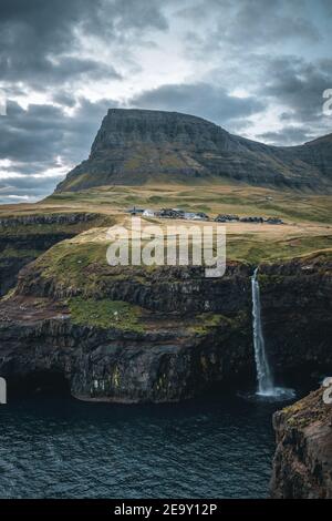 Le village de Gasadalur et Mulafossur sa chute d'eau emblématique au coucher du soleil en été avec le ciel bleu. Gélose, Îles Féroé, Danemark. La plus grossière dans le nord Banque D'Images