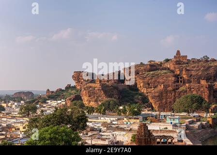 Badami, Karnataka, Inde - 7 novembre 2013 : temples grottes au-dessus du lac Agasthya. Paysage urbain devant les falaises de roche rouge avec le temple de la haute Shivalaya sur Banque D'Images