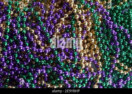 Fond coloré de perles gras de Mardi. Perles de gras de Merdi vert, violet et or Banque D'Images