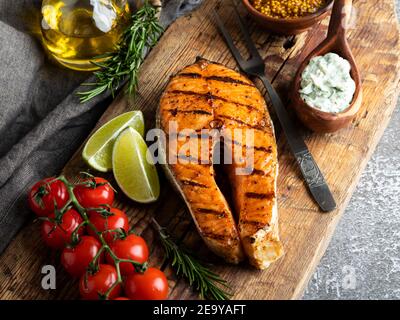 steak grillé saumon au poisson, truite dans un vieux panneau de bois, romarin, tomate, gros plan Banque D'Images