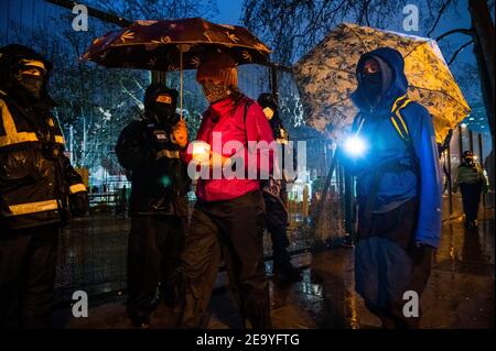 Londres, Royaume-Uni. 6 février 2021. Une veillée aux chandelles marche lentement autour du périmètre - le camp de la rébellion anti HS2 extinction continue d'être libéré (afin de créer une aire de stationnement temporaire) par les Bailiffs (de l'équipe nationale de police, NET, une filiale du High court Enforcement Group) à Euston Station. Tous les manifestants au-dessus du sol ont été dégagés et ils sont maintenant en train de supplirer de creuser les tunnels. Crédit : Guy Bell/Alay Live News Banque D'Images