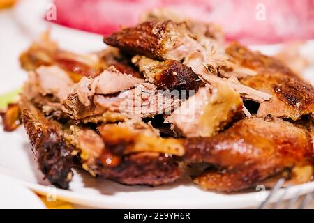 morceaux de canard rôti avec une délicieuse croûte sur une assiette blanche. plat pour la table de fête Banque D'Images