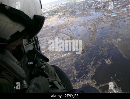 Aviation anti-sous-marine Warfare Operator 2nd Class Timothy Sullivan voit la dévastation au-dessus de Banda Aceh, d'un US Navy SH-60F Seahawk affecté à l'hélicoptère anti-sous-marine Squadron 2 (HS-2) -Golden Falcons.- HS-2 embarqué à bord de l'USS Abraham Lincoln (CVN 72) transporte des fournitures, Mettre en place des équipes de secours en cas de catastrophe et soutenir les avions de transport humanitaire dans les régions côtières touchées par le tsunami. Photo de Patrick M. Bonafede/USN via ABACA Banque D'Images