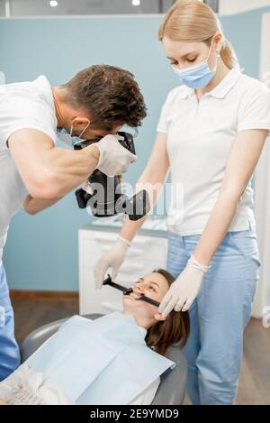 Dentiste photographiant le résultat de son travail Banque D'Images