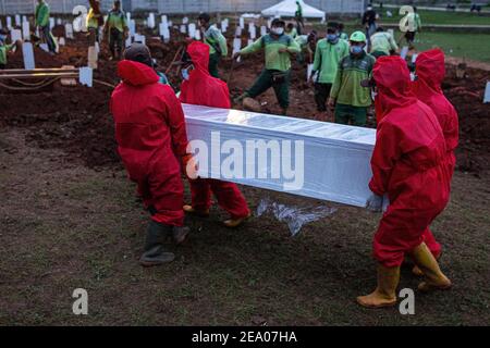 Des digesteurs de graves enterrent un cercueil d'une victime du coronavirus Covid-19 dans un cimetière spécial de Jakarta le 26 janvier 2021. Banque D'Images