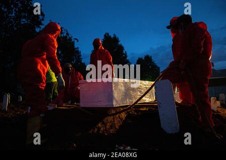 Des digesteurs de graves enterrent un cercueil d'une victime du coronavirus Covid-19 dans un cimetière spécial de Jakarta le 26 janvier 2021. Banque D'Images