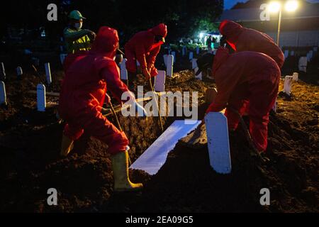 Des digesteurs de graves enterrent un cercueil d'une victime du coronavirus Covid-19 dans un cimetière spécial de Jakarta le 26 janvier 2021. Banque D'Images