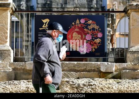 La Valette, Malte. 6 février 2021. Un homme passe devant un panneau de présentation de l'exposition sur la culture chinoise du zodiaque à la Valette, capitale de Malte, le 6 février 2021. Une exposition sur la culture du zodiaque chinois a eu lieu ici en ligne et hors ligne dans le cadre d'événements célébrant le Festival du printemps chinois, qui se tient le 12 février. Credit: Jonathan Borg/Xinhua/Alay Live News Banque D'Images