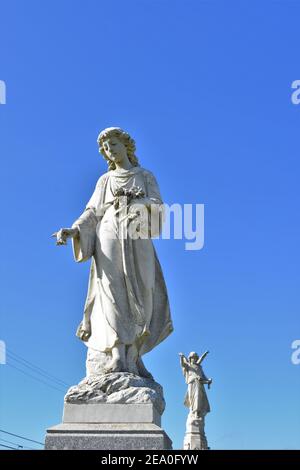 Statues d'ange dans un cimetière public catholique de Californie avec ciel ouvert qui est clair, d'avant la guerre mondiale 2 les inhumations pour les familles locales et copie Banque D'Images