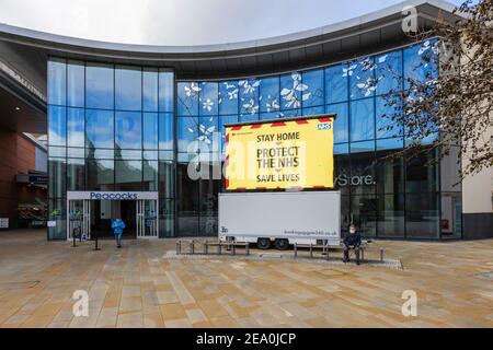 Panneau lumineux avec verrouillage COVID-19 message « Protect the NHS, Save Lives » à Jubilee Square, centre-ville de Woking, Surrey, sud-est de l'Angleterre Banque D'Images