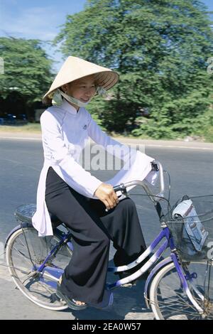 Asie, Vietnam, delta du Mékong, jolies jeunes étudiantes portant une robe traditionnelle vietnamienne Aoi- Dai à vélo à l'école Banque D'Images