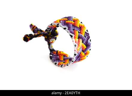 Mise au point sélective d'un bracelet d'amitié tissé avec des couleurs vives motif fait à la main de fil isolé sur fond blanc Banque D'Images