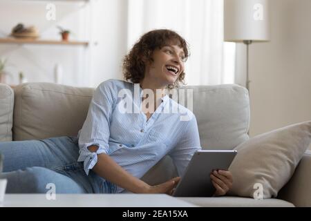 Une femme heureuse se repose sur une tablette de navigation Banque D'Images