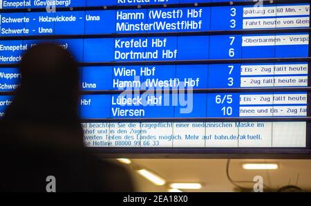 Hagen, Allemagne. 07e février 2021. Un homme se tient devant le panneau d'affichage de la gare principale, où de nombreux trains sont annoncés comme annulés et retardés. Pendant la nuit, il y a eu de fortes chutes de neige dans de grandes parties de la Rhénanie-du-Nord-Westphalie. Credit: Jonas Güttler/dpa/Alay Live News Banque D'Images